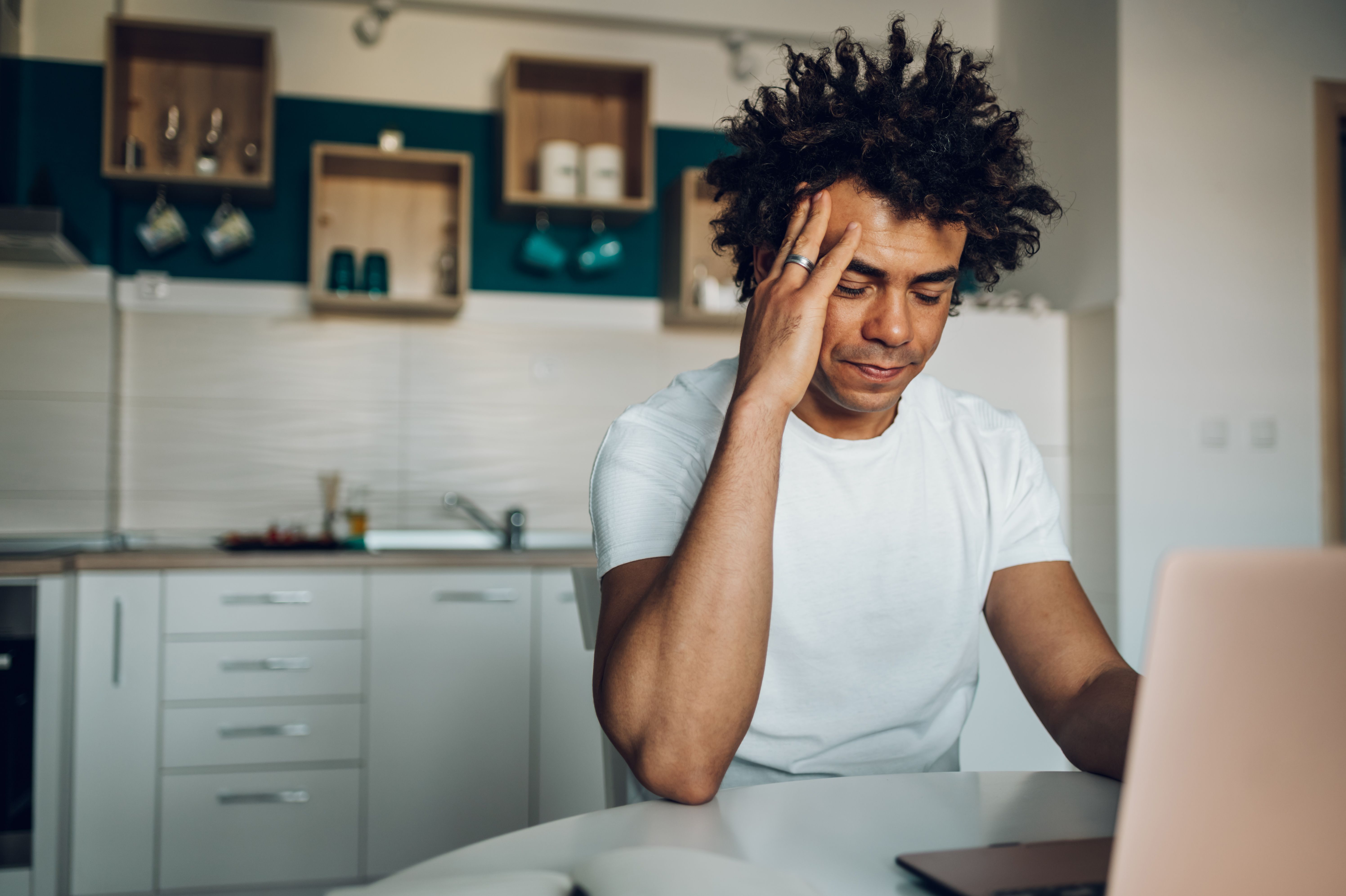 Gestresste man achter zijn laptop vanwege een vast energiecontract en zonnepanelen